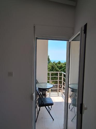 a door leading to a balcony with a table and chairs at Jasmin 3 in Ulcinj