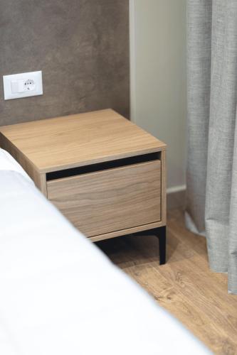 a wooden night stand next to a bed at Siel Hotel in Durrës