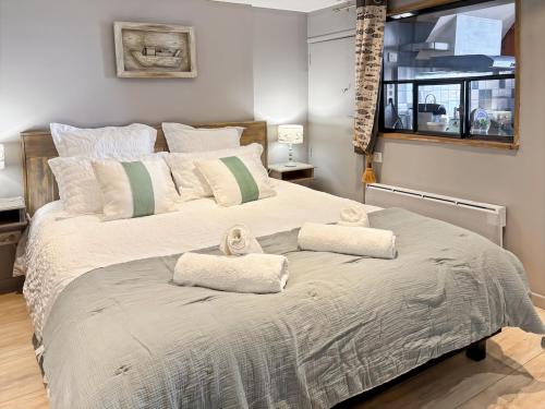 une chambre avec un grand lit avec des serviettes dessus dans l'établissement Nous y Somme, bel appartement face à la Baie, à Saint-Valery-sur-Somme