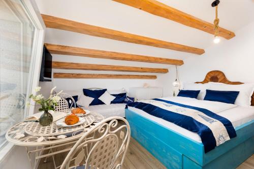 a bedroom with a bed and a table and chairs at Vila Mare in Risika