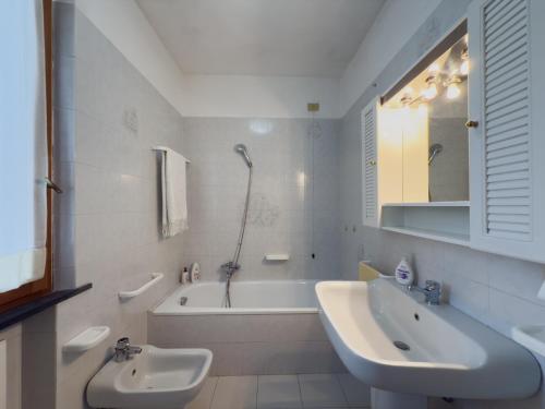 a white bathroom with a tub and a sink and a bath tub at La Terrazza al Forte in Forte dei Marmi