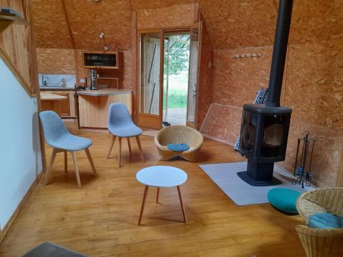 a living room with a wood stove in a room at Chambres en roulotte sur lieu atypique de ressourcement in Mauzac-et-Grand-Castang