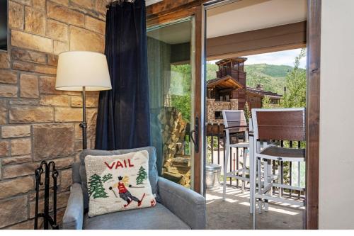 un soggiorno con una sedia e una finestra di Rooftop Hot Tub, Free Parking, Renovated condo in the Heart of Lionshead a Vail