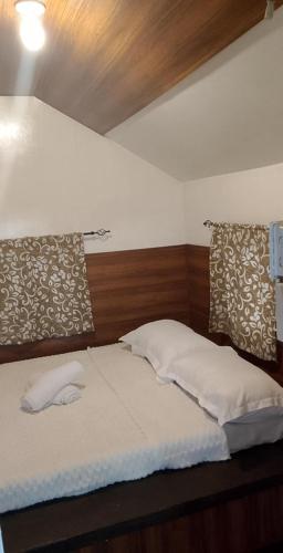 a bed with two pillows on it in a room at Seabreeze Beachfront Home and Cottages new management in San Juan