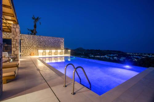 a swimming pool in a villa at night at Athoros Luxury Villas in Afantou