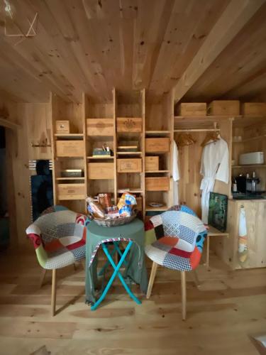 - une chambre avec deux chaises et une table dans l'établissement L'Aquarium de Proust sous les arbres, à Lacanau