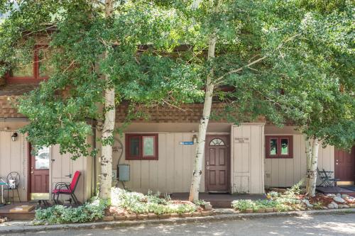 a house with two trees and a red chair at On Gore Creek, Pet Friendly, Steps from Free Bus Stop & Great Value in Vail