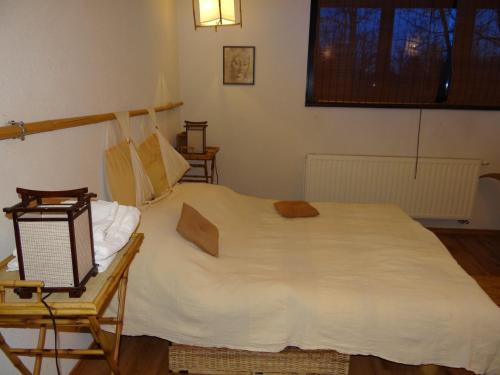Un dormitorio con una gran cama blanca y una silla. en Pensiunea Bamboo - Villa, en Breaza
