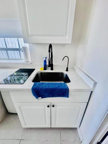 a kitchen sink with a blue towel next to it at Tempurpedic Queen - Laundry, Parking & EV Charger in Hollywood