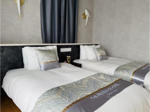 una camera d'albergo con due letti in una stanza di The Residence Hotel Okayama - Vacation STAY 43031v a Okayama
