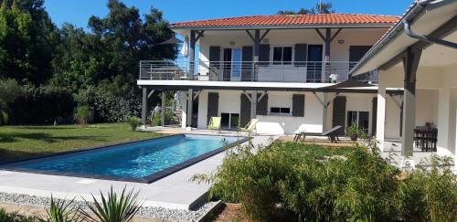 une maison avec une piscine devant dans l'établissement Appartement Vieux Boucau, à Vieux-Boucau-les-Bains