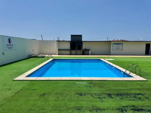 an empty swimming pool in a grassy yard at Bella Cena in São Roque