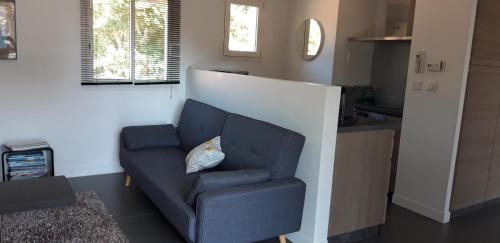 - un canapé bleu avec un oreiller dans l'établissement Appartement Vieux Boucau, à Vieux-Boucau-les-Bains