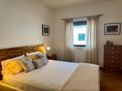 Un dormitorio con una cama grande y una ventana. en Bella Cena, en São Roque