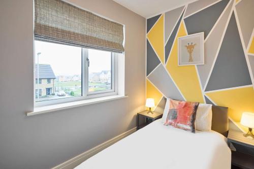 ein Schlafzimmer mit einem Bett und einem großen Fenster in der Unterkunft Modern Home with Garden, Corby in Corby and Weldon