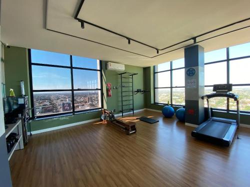 an empty room with a gym with large windows at Apartamento Sunset Residence in Dourados