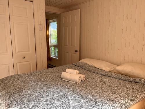 a bedroom with a bed with two folded towels on it at Camping Chalets Lac St-Augustin in Quebec City