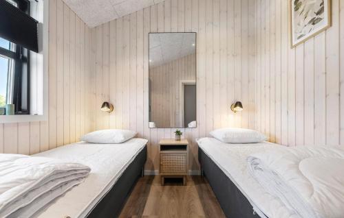 two beds in a room with a mirror at Gorgeous Home In Haderslev in Haderslev