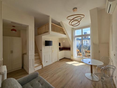 un salon avec un escalier et un canapé dans l'établissement Little LV2 Au cœur de l'Avenue des Champs-Elysées Arc de Triomphe, à Paris