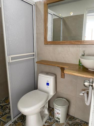 a bathroom with a toilet and a sink and a mirror at Blanca House in Arboletes