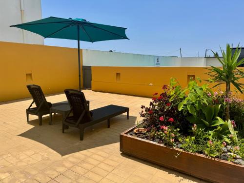 a patio with two chairs and a table with an umbrella at Bella Cena in São Roque