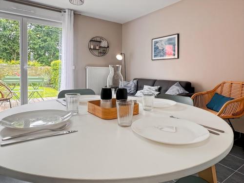 - une table blanche avec des assiettes dans le salon dans l'établissement Les pâquerettes, jardin, garage, parking gratuit, à Saint-Valery-sur-Somme