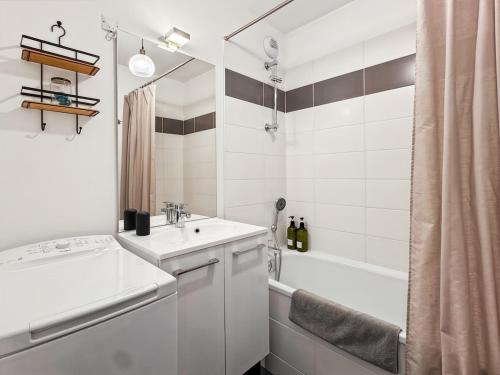 une salle de bain blanche avec un lavabo et une douche dans l'établissement Les pâquerettes, jardin, garage, parking gratuit, à Saint-Valery-sur-Somme