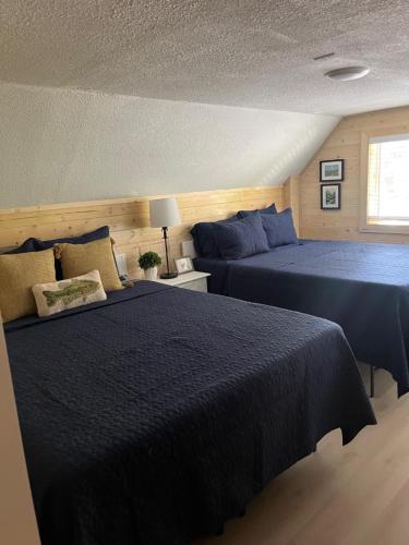 a bedroom with two beds and a window at glacier creek apartment in Seward