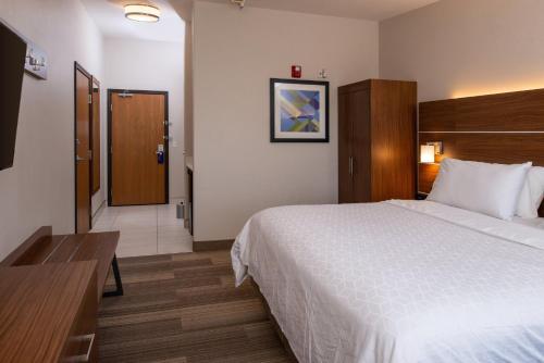 a hotel room with a large bed and a door at Holiday Inn Express Hotel & Suites Gunnison by IHG in Gunnison