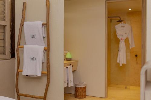 a bathroom with a towel rack and a robe at Hotel San Pedro de Majagua in Isla Grande