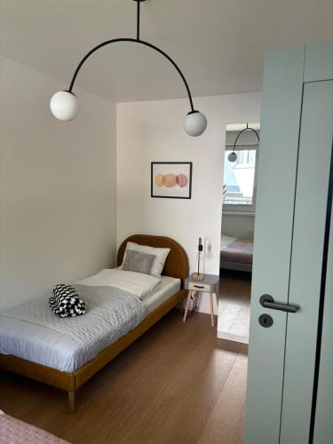 a bedroom with a bed and two lights above it at Dębina Lounge 20 Apartamenty in Debina