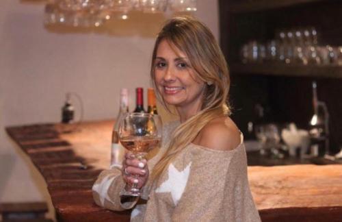 a woman is holding a glass of wine at Hotel Boutique Santa Clara Mesa de los Santos in Los Santos