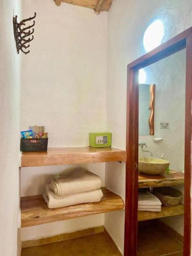 a bathroom with a sink and a shelf with towels at Hotel Boutique Santa Clara Mesa de los Santos in Los Santos