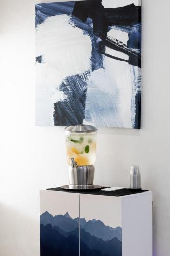 a drink on a table in front of a painting at Holiday Inn Express & Suites Chicago West - St Charles by IHG in Saint Charles