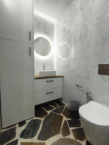 a white bathroom with a sink and a toilet at MAGIA's HOUSE in Karistos
