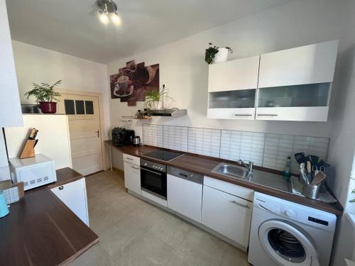 a kitchen with white cabinets and a washing machine at TheGreenCapital in Berlin
