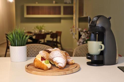 a coffee maker and a plate of pastries on a table at Lovely holiday home next to Bus terminus in St Paul's Bay