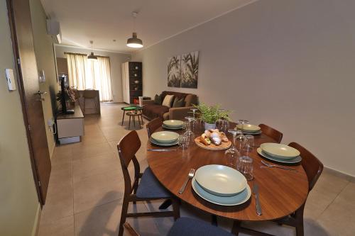 a wooden table with chairs and a dining room at Lovely holiday home next to Bus terminus in St Paul's Bay