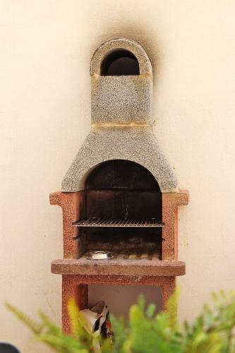 a brick oven sitting on the side of a wall at Lovely holiday home next to Bus terminus in St Paul's Bay