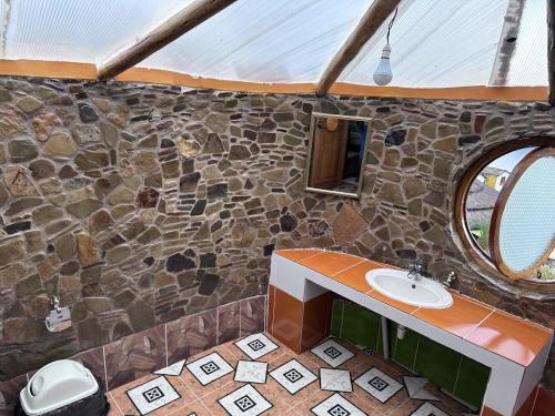 a stone bathroom with a sink and a mirror at PALLA KHASA ECOFRIENLY Hotel in Comunidad Yumani