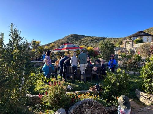 a group of people sitting under a tent in a garden at PALLA KHASA ECOFRIENLY Hotel in Comunidad Yumani