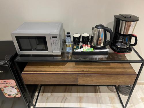 a microwave oven sitting on top of a table at سويت بغرفة نوم وصالة جانبية in Hail