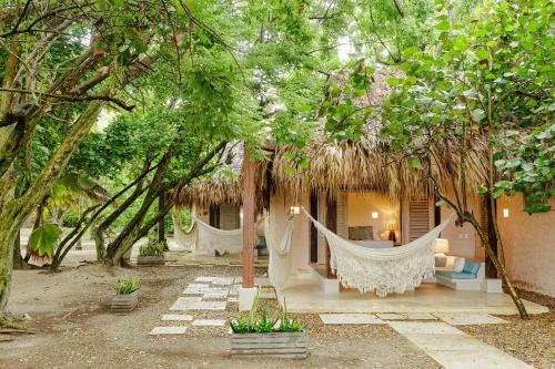 a house with hammocks in the middle of trees at Hotel San Pedro de Majagua in Isla Grande
