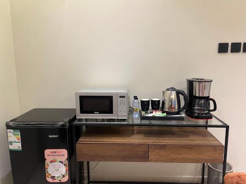 a microwave sitting on top of a counter with a refrigerator at سويت بغرفة نوم وصالة جانبية in Hail