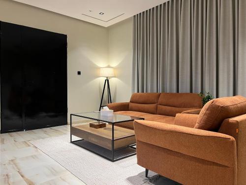 a living room with a couch and a glass table at سويت بغرفة نوم وصالة جانبية in Hail