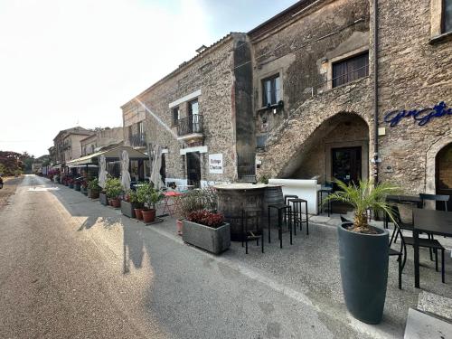 an empty street with tables and potted plants in front of a building at La Maisonette di Paestum - Vicino ai Templi & Wi-Fi gratuito in Paestum