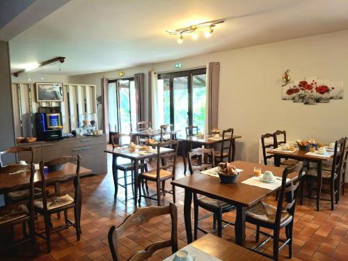 a restaurant with tables and chairs in a room at Relais de Frejeroques in Foissac