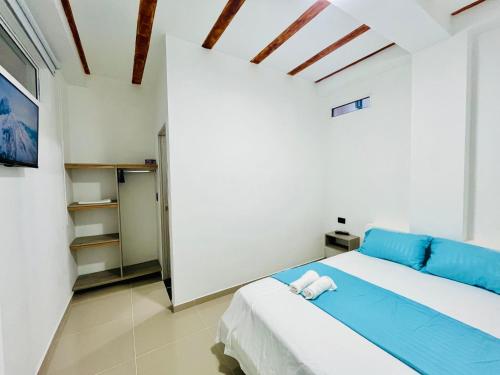 a bedroom with a large bed with blue sheets at Amanecer Santorini in Estación El Salto
