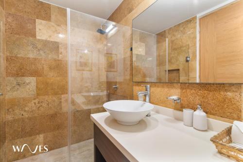 a bathroom with a sink and a large mirror at Luminous 1 Br. Steps away from the Beach in Playa del Carmen