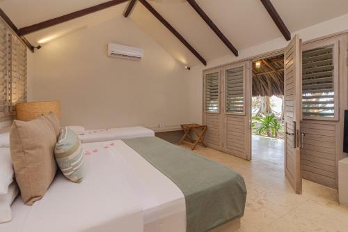 a bedroom with a large white bed in a room at Hotel San Pedro de Majagua in Isla Grande